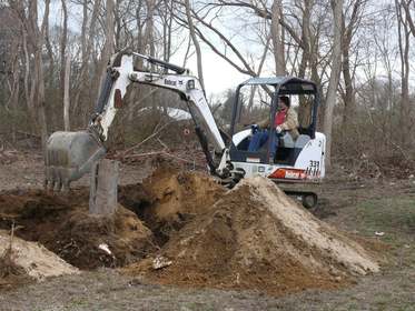 Tracked backhoe stump removal